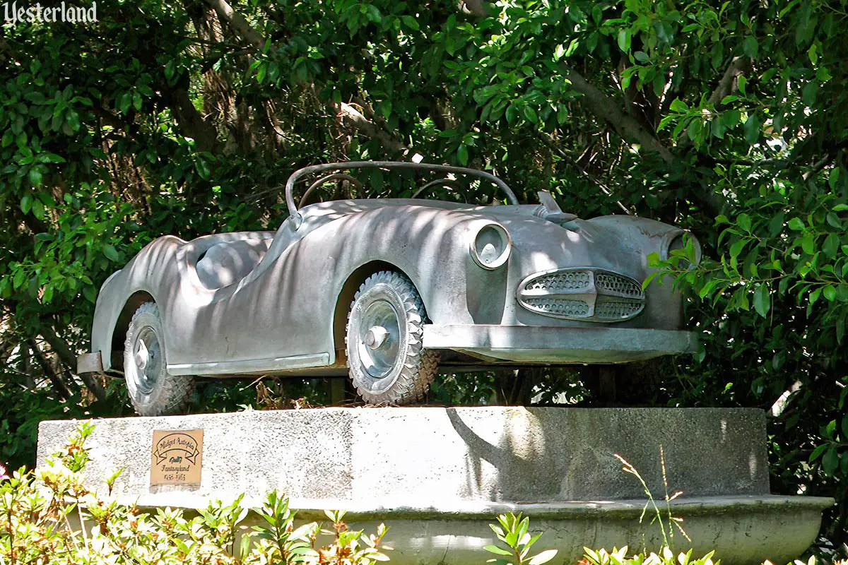Disneyland Midget Autopia car as a sculpture along the Autopia roadway